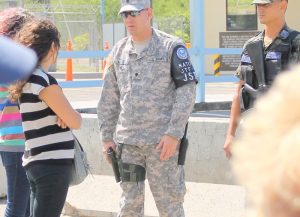 A US soldier grips his pistol as he orders members of a human rights delegation off the grounds of Soto Cano Air Force Base outside of Tegucigalpa in 2012. The base is where President Manuel Zelaya was initially flown after he was kidnapped by the military in a 2009 coup. (photo: The Nation Report)