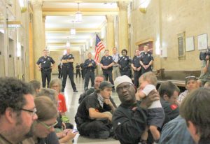 Dozens participate in a sit-in outside of City Council Chambers following a split council vote to approve Denver’s Unauthorized Camping Ban on May 15, 2012. (all photos: The Nation Report)